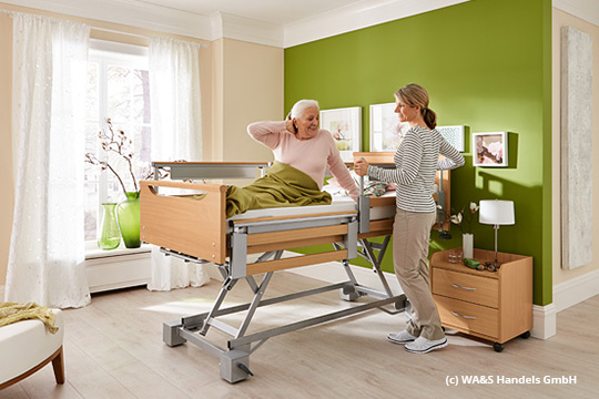 Pflegesituation mit älterem Menschen im Pflegebett und einer Krankenschwester in einem grün gehaltenen Krankenzimmer