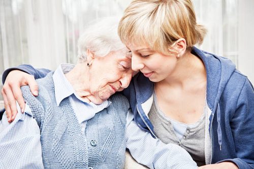 Senior woman, 89 years old, getting comfort by  young home caregiver